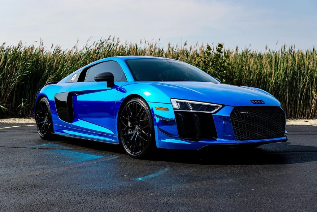Glossy blue Audi R8 parked on clean pavement, its flawless finish reflecting light under the sun. The vehicle's well-preserved exterior illustrates how Paint Protection Film helps maintain showroom-quality appearance and supports higher resale value.