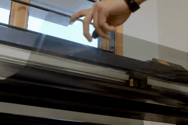 A technician carefully applies a thin, transparent tint film onto a car window in a workshop near Naperville, Illinois, showing what is window tinting and how it enhances UV protection and interior preservation.